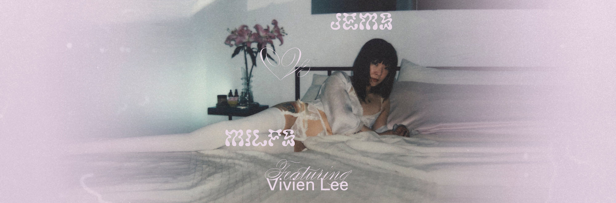 Vivien Lee lounging in bed wearing white lingerie